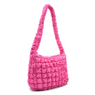 side view of a hot pink colored quilted nylon hobo style crossbody sling bag
