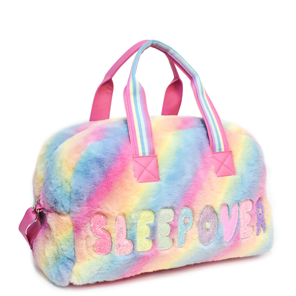 Side view of large plush ombre 'sleepover' duffle with glitter bubble-letter patches