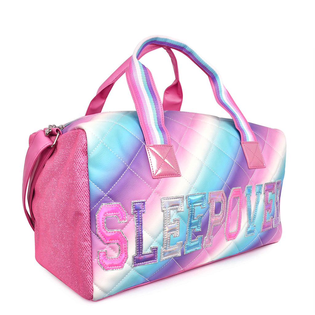 Side view of cool-toned quilted ombre large 'Sleepover' duffle with reflective varsity-letter patches
