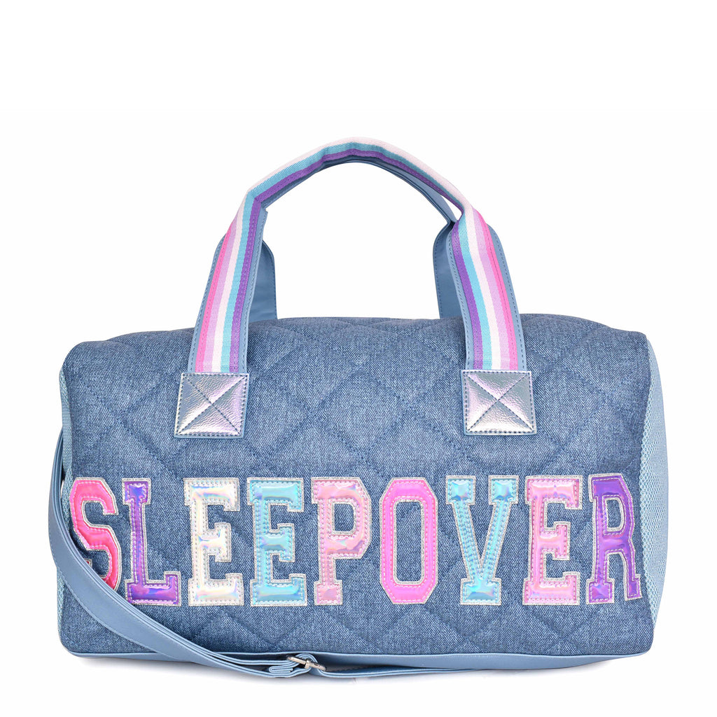 Front view of denim quilted large duffle bag with shoulder strap and metallic varsity letters 'SLEEPOVER'